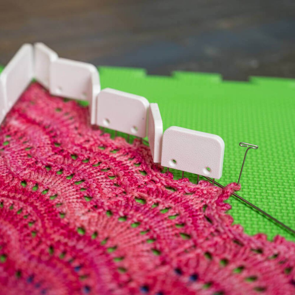 KnitPro Original Knit Blockers shaping a pink lace project on foam mats