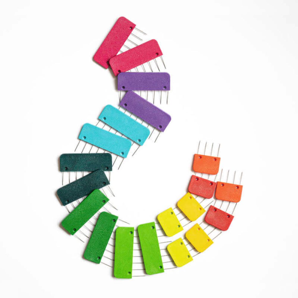 Large and small KnitPro Rainbow Knit Blockers arranged by colour