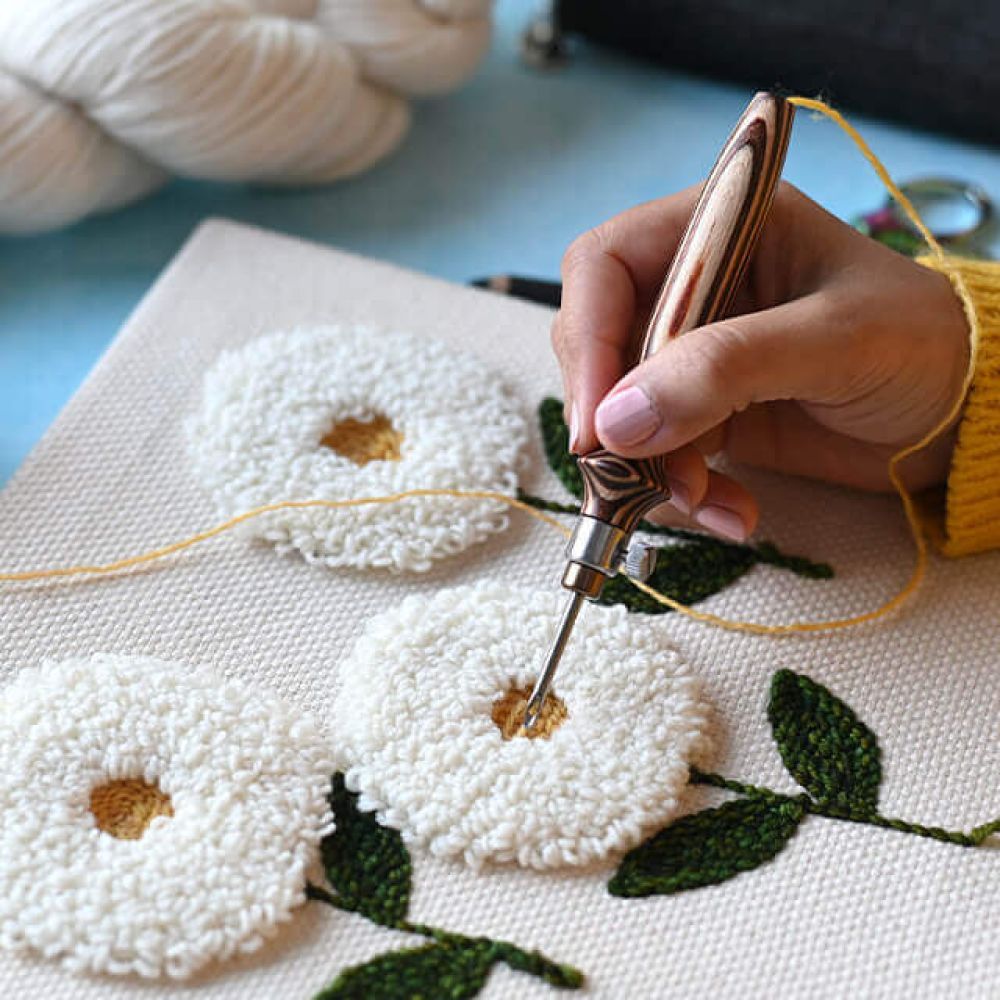 KnitPro Earthy adjustable punch needle making textured white flowers on foundation fabric